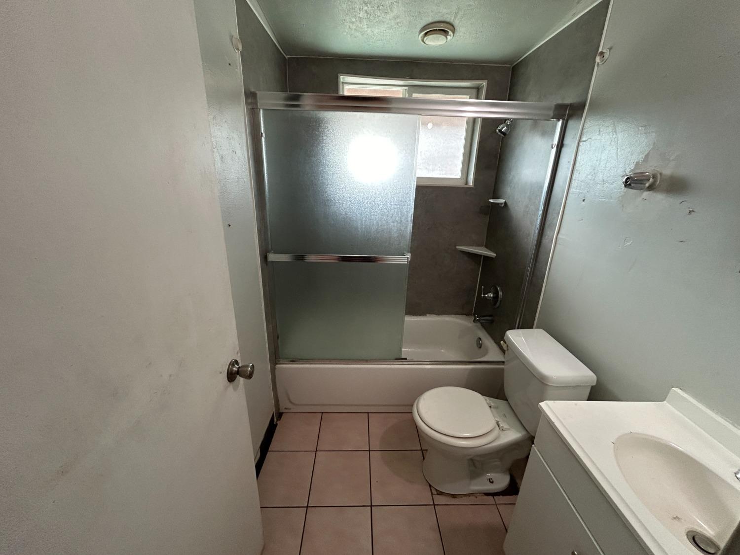 236 K Street Sanger, CA 93657 - Photo 9 of 23 a white toilet sitting next to a bathroom sink and a mirror