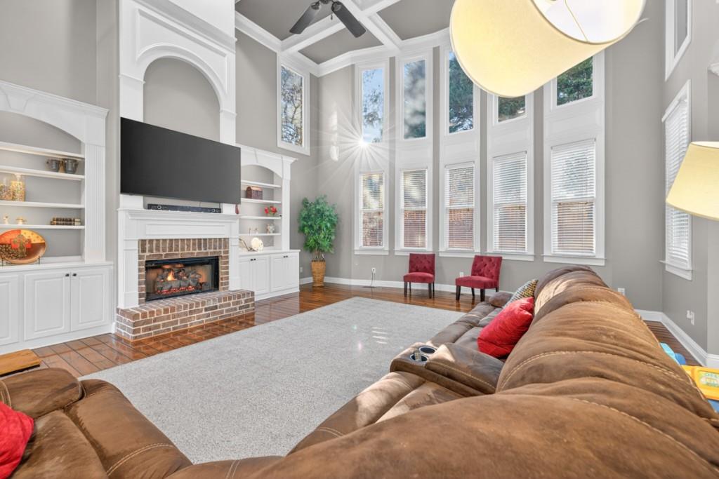 8023 Sleepy Lagoon Way Flowery Branch, GA 30542 - Photo 15 of 79 a living room with furniture a flat screen tv and a fireplace