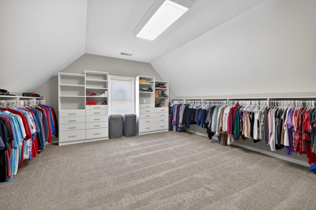 8023 Sleepy Lagoon Way Flowery Branch, GA 30542 - Photo 36 of 79 a view of walk in closet with clothes and shoes
