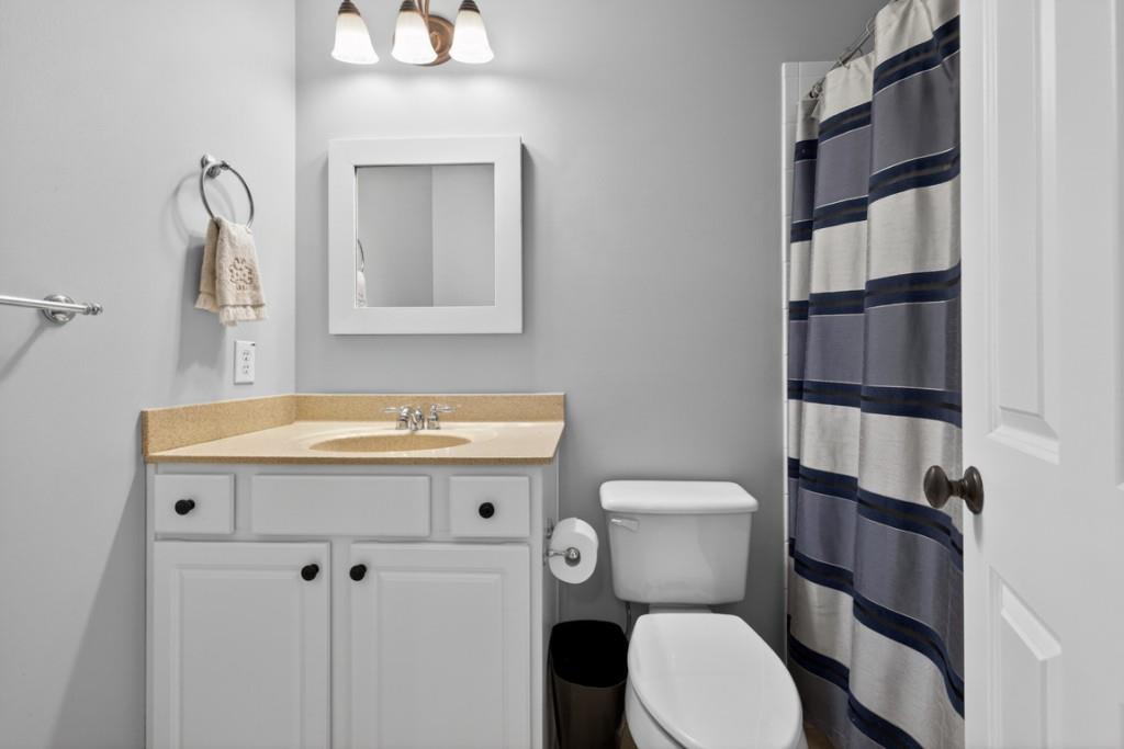 8023 Sleepy Lagoon Way Flowery Branch, GA 30542 - Photo 40 of 79 a bathroom with a toilet a sink and a mirror