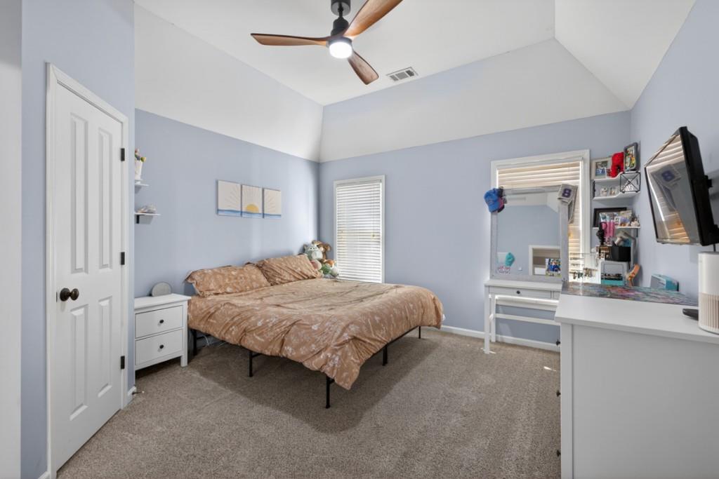 8023 Sleepy Lagoon Way Flowery Branch, GA 30542 - Photo 42 of 79 a bedroom with a bed and a flat tv screen on the dresser