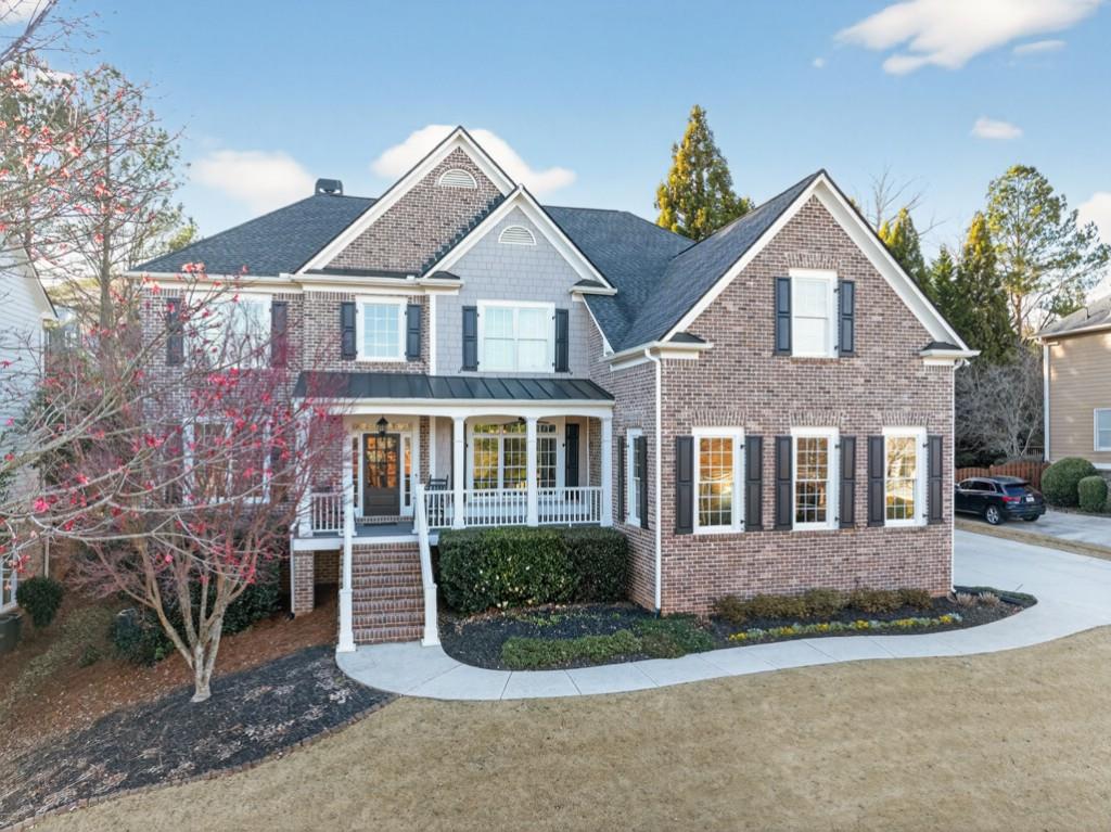 8023 Sleepy Lagoon Way Flowery Branch, GA 30542 - Photo 57 of 79 a view of a brick house with a yard plants and large tree