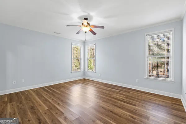a view of a room with wooden floor and ceiling fan