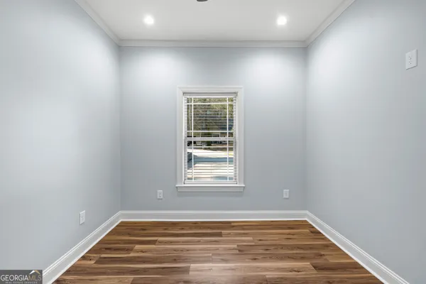 an empty room with a window and ceiling fan