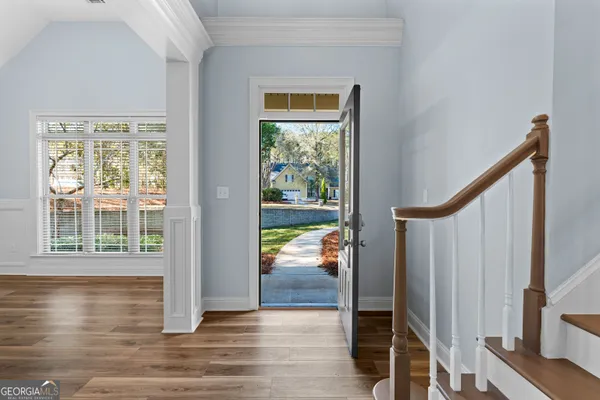 a view of a hallway with wooden floor and staircase