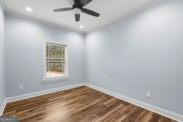 a view of a livingroom with wooden floor and a ceiling fan