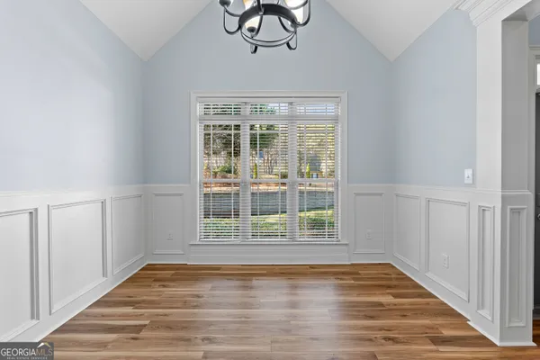 a view of an empty room with wooden floor and a fireplace