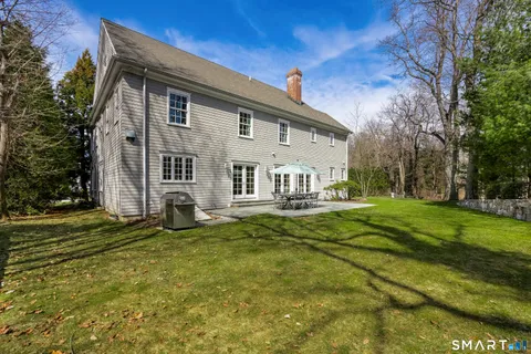 a view of a house with a yard patio and a tree
