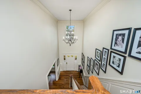 a view of a livingroom with furniture stairs wooden floor and windows