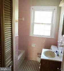 1452 Barrett Road Baltimore, MD 21207 - Photo 12 of 18 a bathroom with a sink a bath tub and a window
