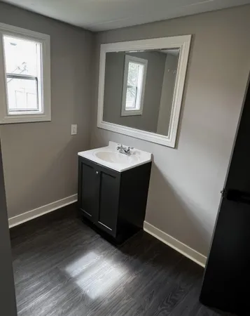 a bathroom with a toilet and a hard wood floor