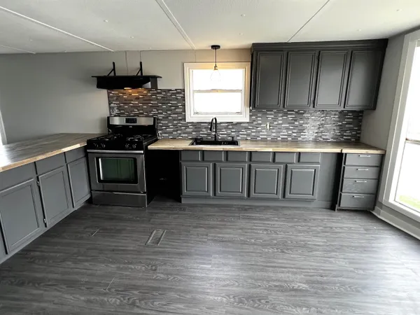 a kitchen with stainless steel appliances granite countertop a sink stove and cabinets