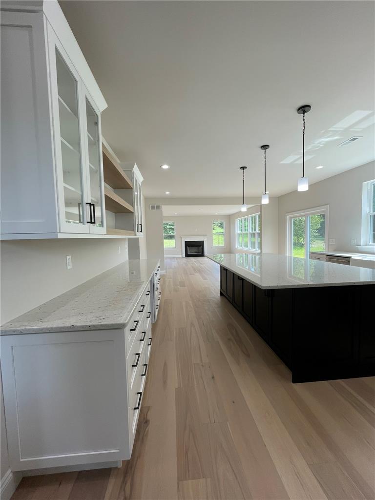 5043 Chapmans Road Orefield, PA 18069 - Photo 17 of 30 An open-concept living space features light wood flooring, white cabinetry, and granite countertops.