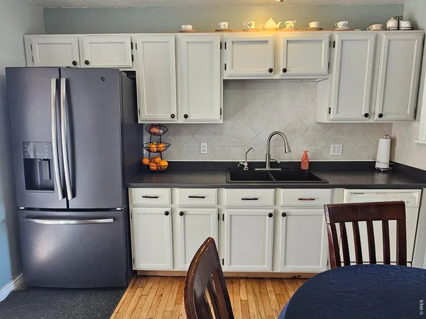 a kitchen with white cabinets and stainless steel appliances