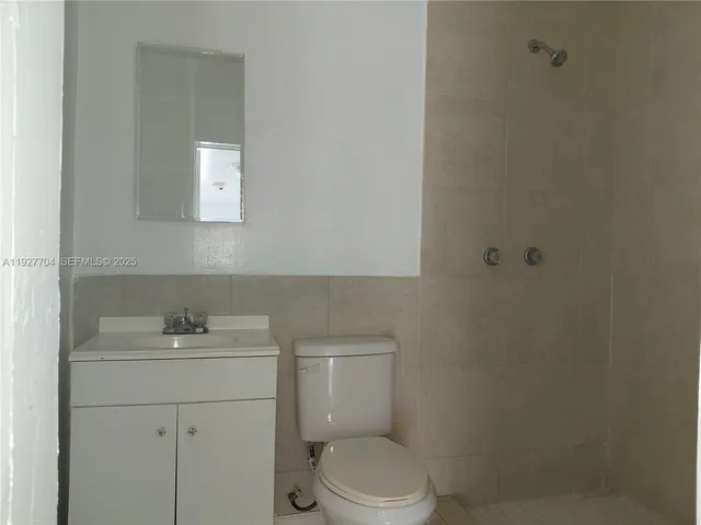 a bathroom with a toilet sink vanity and mirror