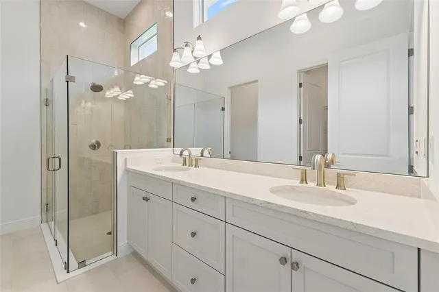 a bathroom with a double vanity sink mirror and shower