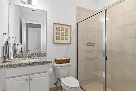 a bathroom with a granite countertop sink toilet and shower