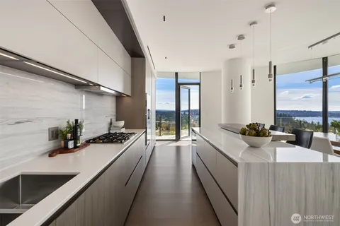 a kitchen with stainless steel appliances kitchen island a table chairs in it and white cabinets