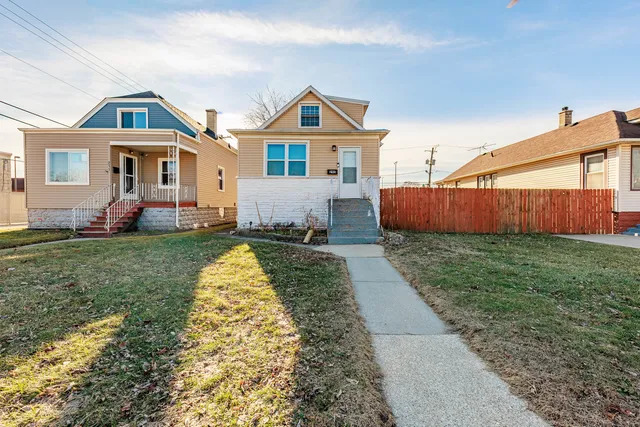 a front view of a house with a yard and trees