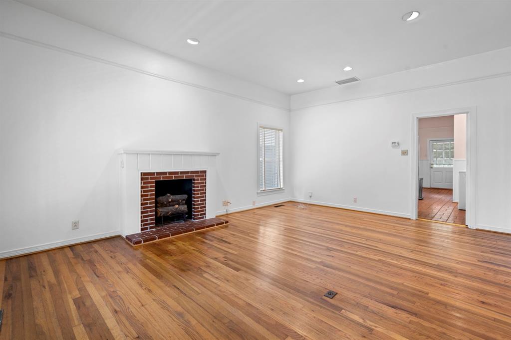 4407 Bonham Street Dallas, TX 75229 - Photo 4 of 22 an empty room with wooden floor and fireplace
