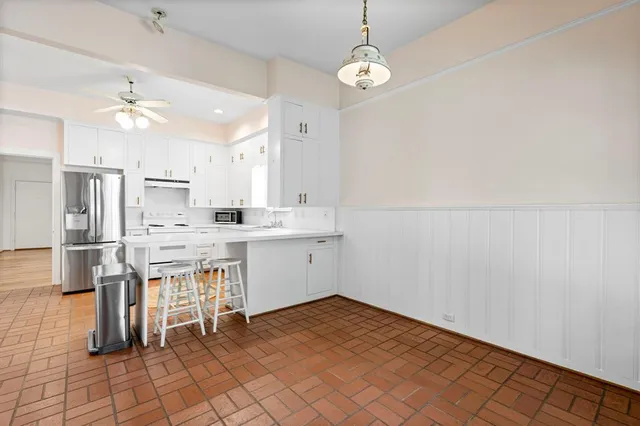 a kitchen with cabinets and chairs