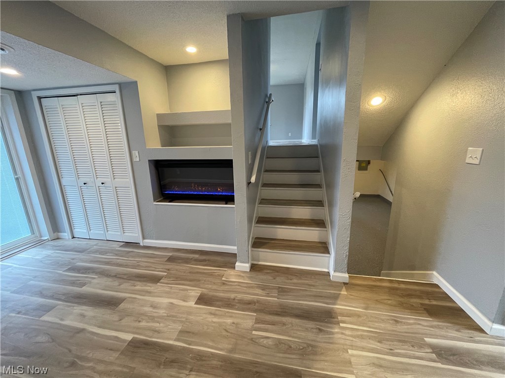 6135 California Road Williamsfield, OH 44093 - Photo 7 of 37 Stairs featuring built in shelves, a textured ceiling, and hardwood / wood-style floors