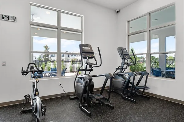 a room with gym equipment and large windows