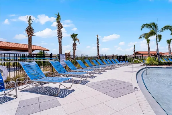 an aerial view of a swimming pool with outdoor seating