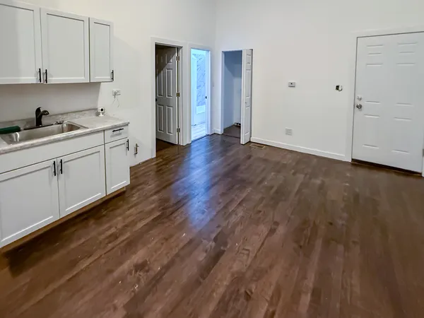 a kitchen with wooden floors and cabinets