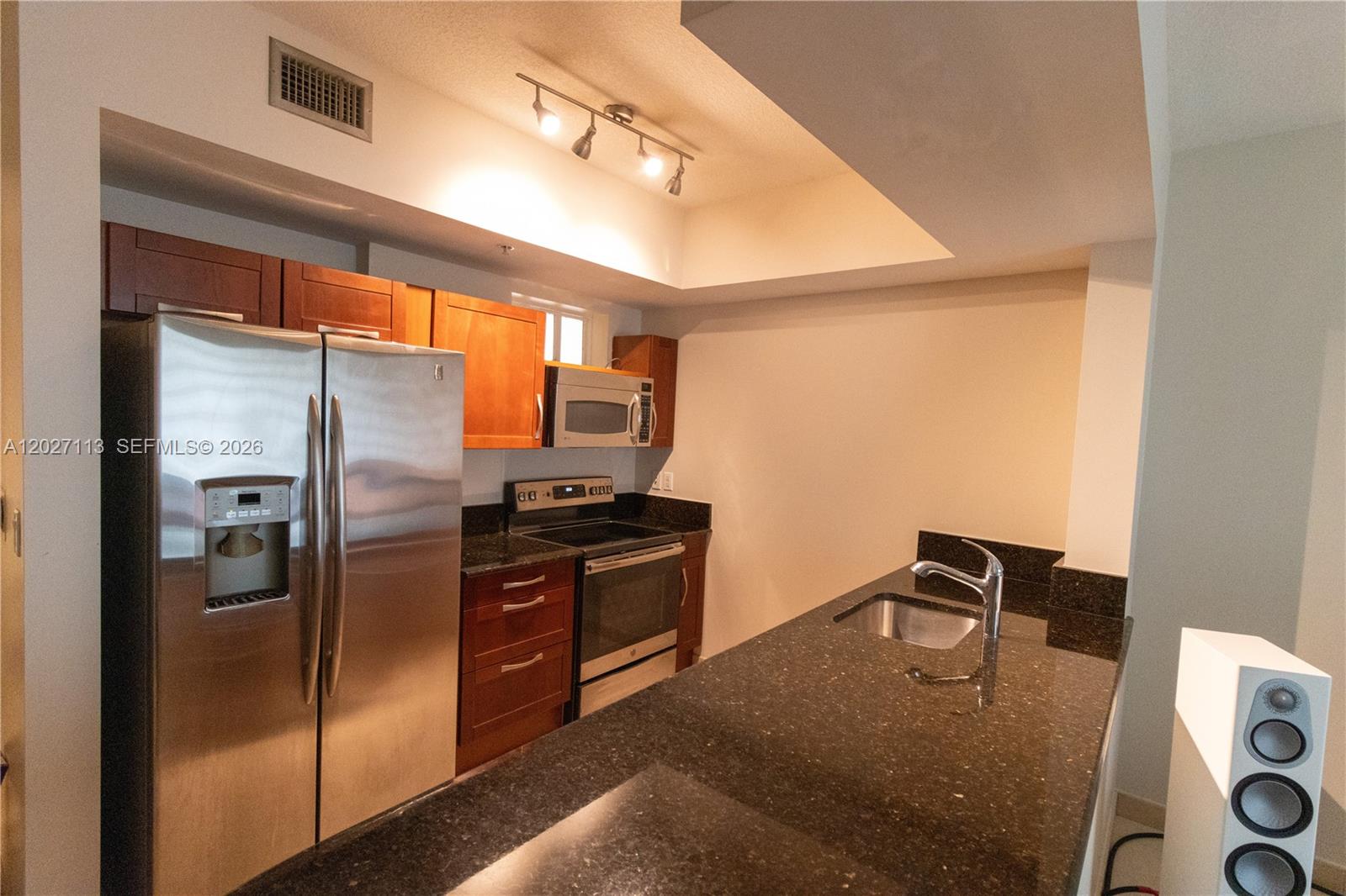 7275 Southwest 90th Way, Unit 213 Miami, FL 33156 - Photo 14 of 31 a kitchen with stainless steel appliances granite countertop a refrigerator a stove and a sink with cabinets