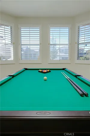 a room with pool table and windows