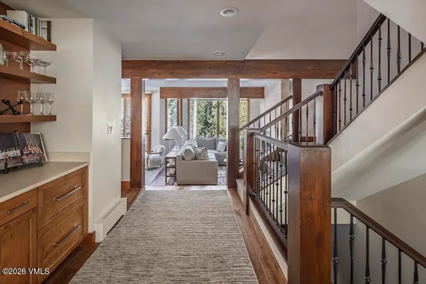 a view of a hallway with wooden floor and stairs