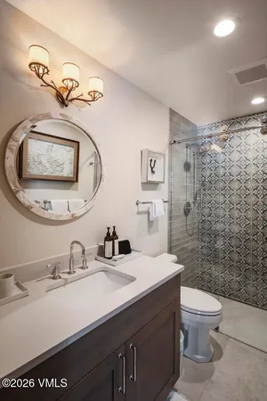a bathroom with a sink a toilet and shower