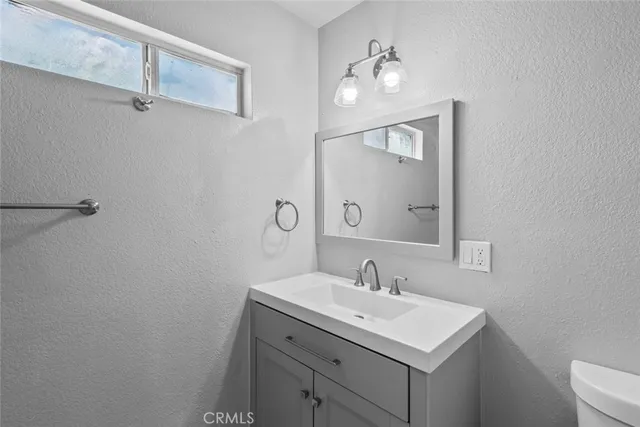 a bathroom with a sink toilet and mirror