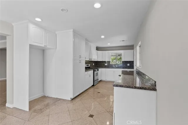a kitchen with granite countertop a refrigerator and a sink