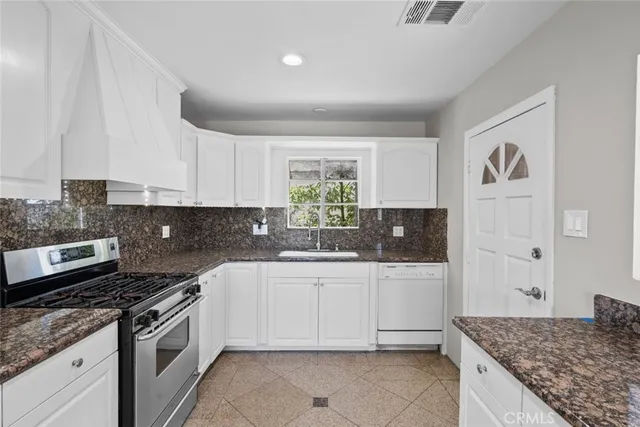 a kitchen with granite countertop a sink and cabinets