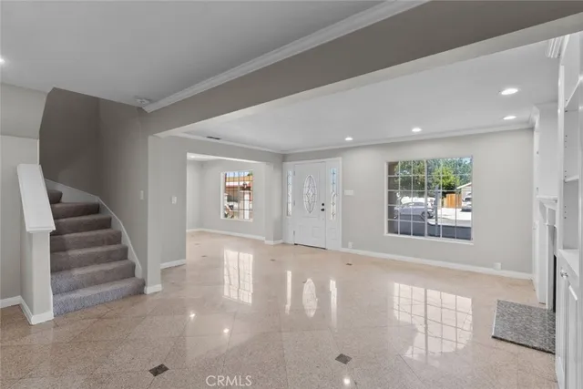 a view of an empty room with stairs and a window