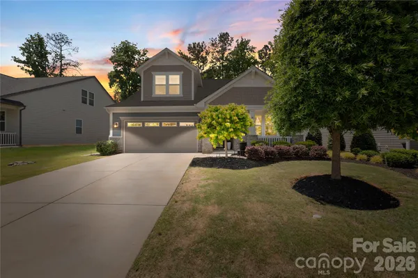a front view of a house with a yard and a garden