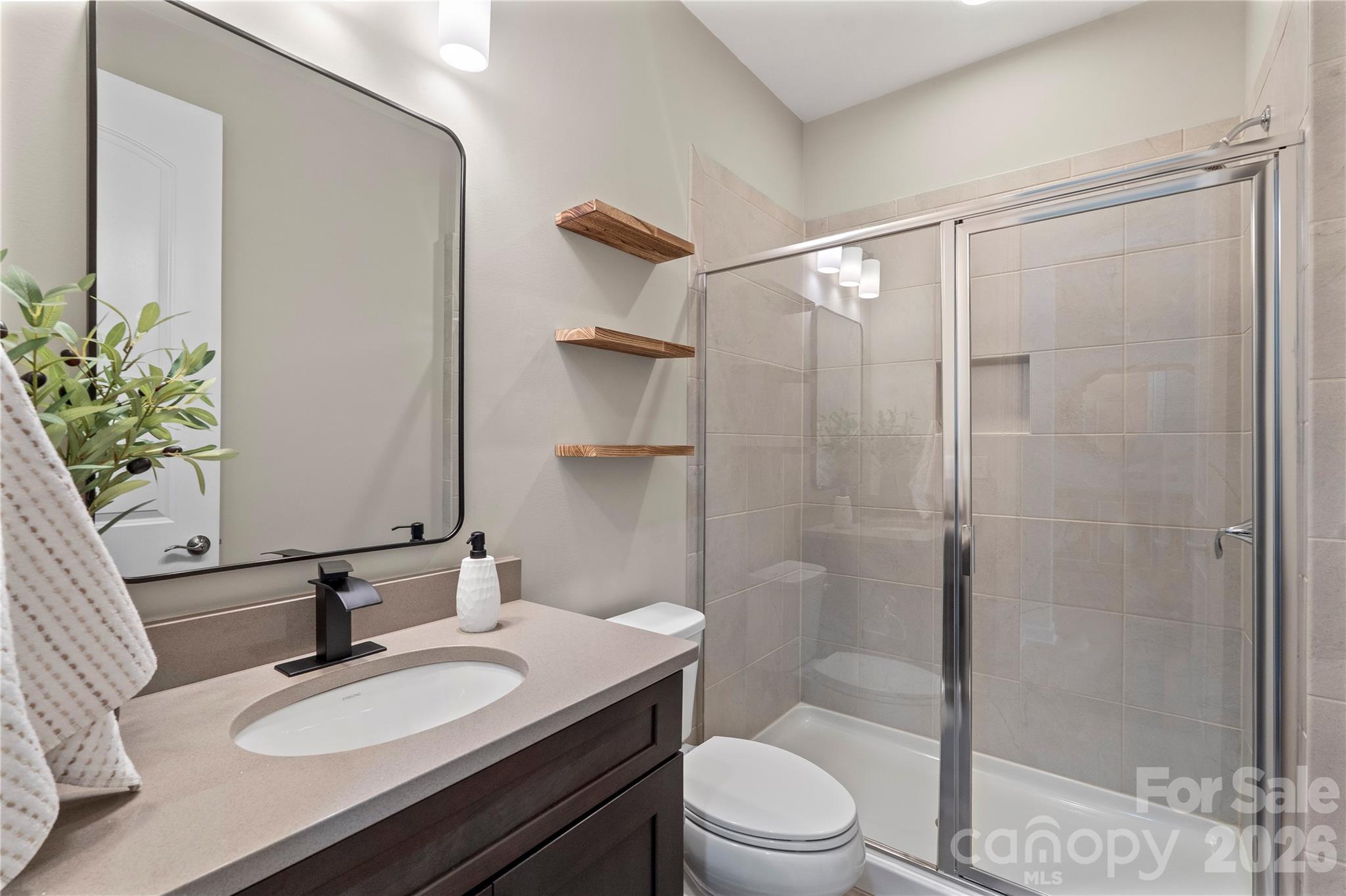 445 Sandbar Point Clover, SC 29710 - Photo 30 of 48 a bathroom with a granite countertop sink toilet a mirror and shower