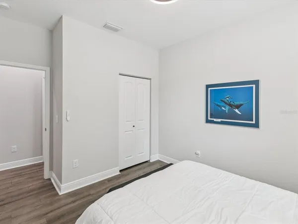 a bedroom with a bed and a wall painting