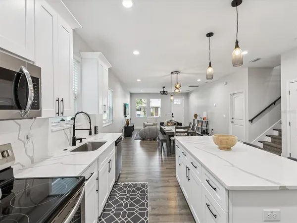 a large kitchen with stainless steel appliances kitchen island granite countertop a sink dishwasher a stove and a stove with wooden floor