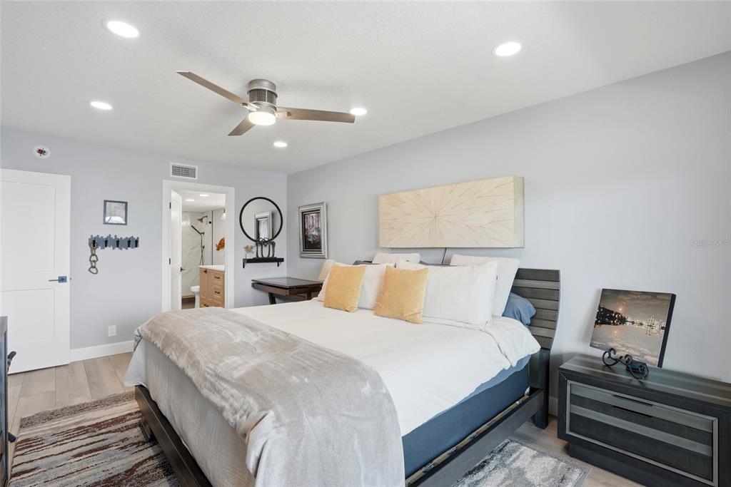 363 Pinellas Bayway South, Unit 29 Tierra Verde, FL 33715 - Photo 23 of 59 a spacious bedroom with a bed and a chandelier