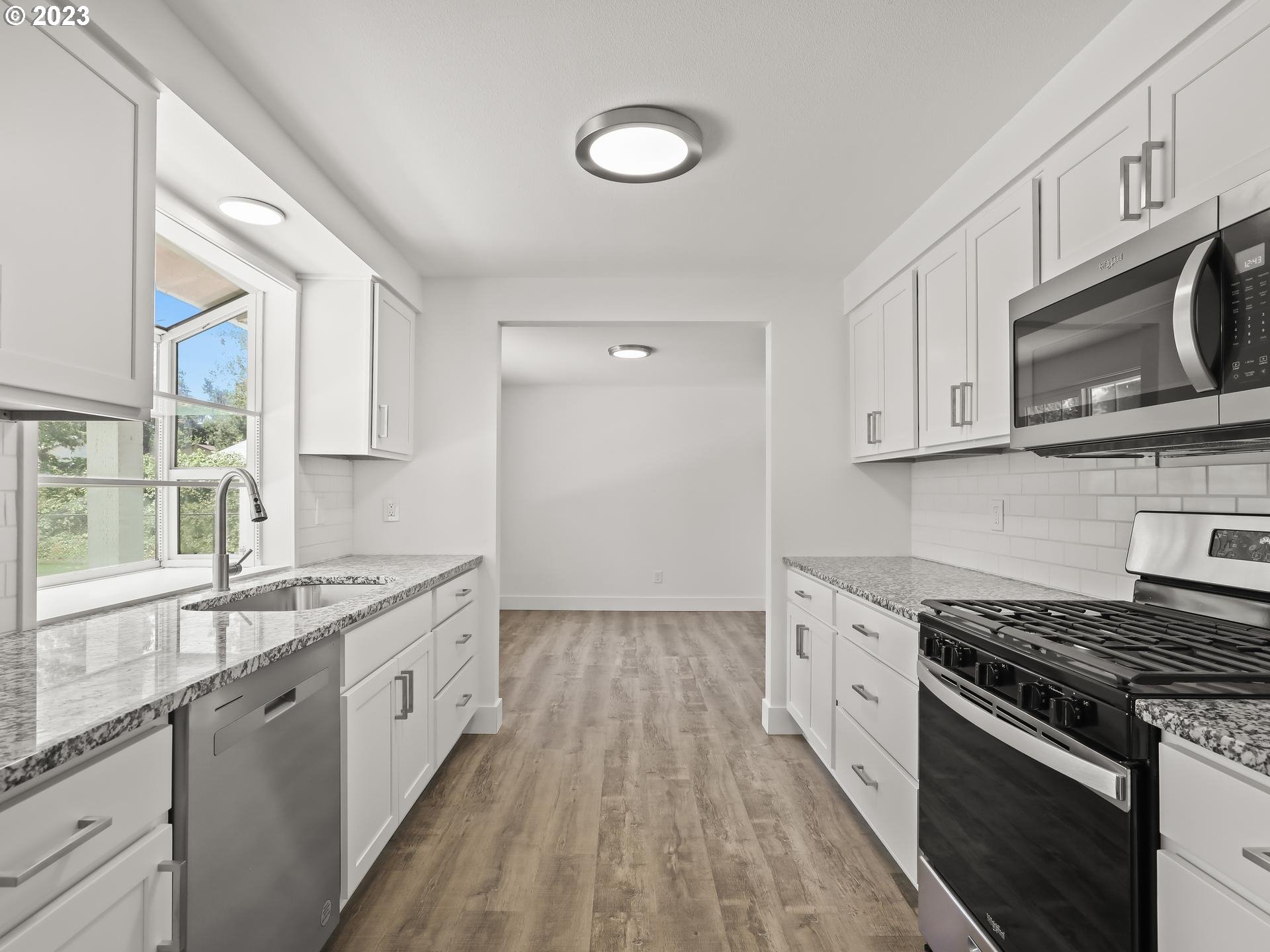 19650 Southwest Celebrity Street Beaverton, OR 97078 - Photo 11 of 47 a kitchen with stainless steel appliances granite countertop a stove a sink and a microwave