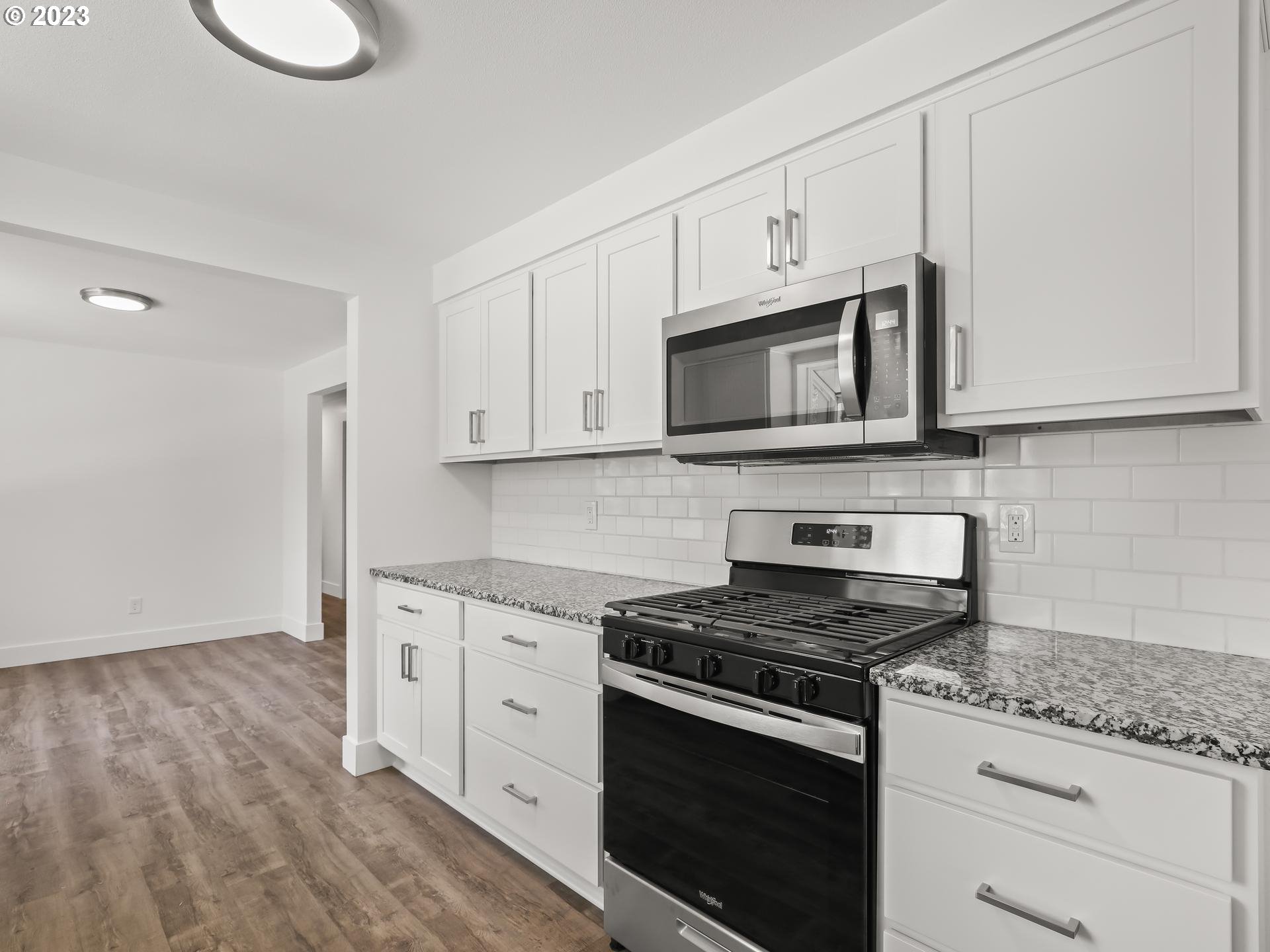19650 Southwest Celebrity Street Beaverton, OR 97078 - Photo 12 of 47 a kitchen with granite countertop cabinets stainless steel appliances and wooden floor