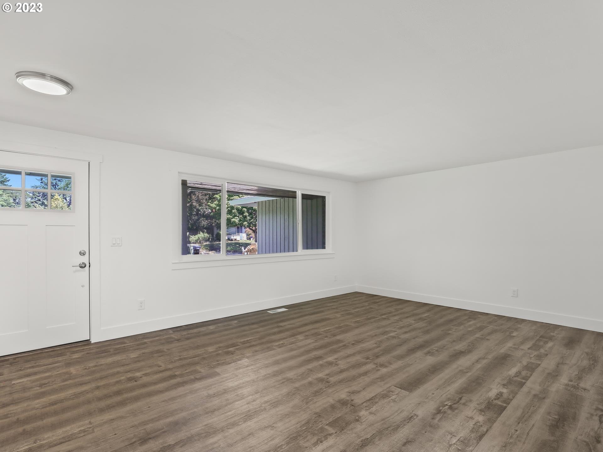 19650 Southwest Celebrity Street Beaverton, OR 97078 - Photo 5 of 47 a view of an empty room with wooden floor and a window
