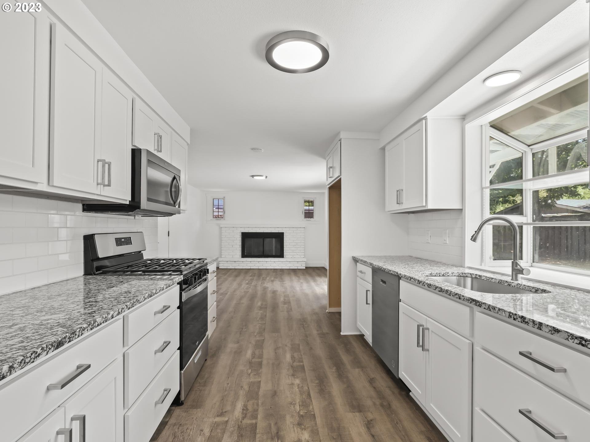 19650 Southwest Celebrity Street Beaverton, OR 97078 - Photo 8 of 47 a kitchen with granite countertop a sink stove and cabinets