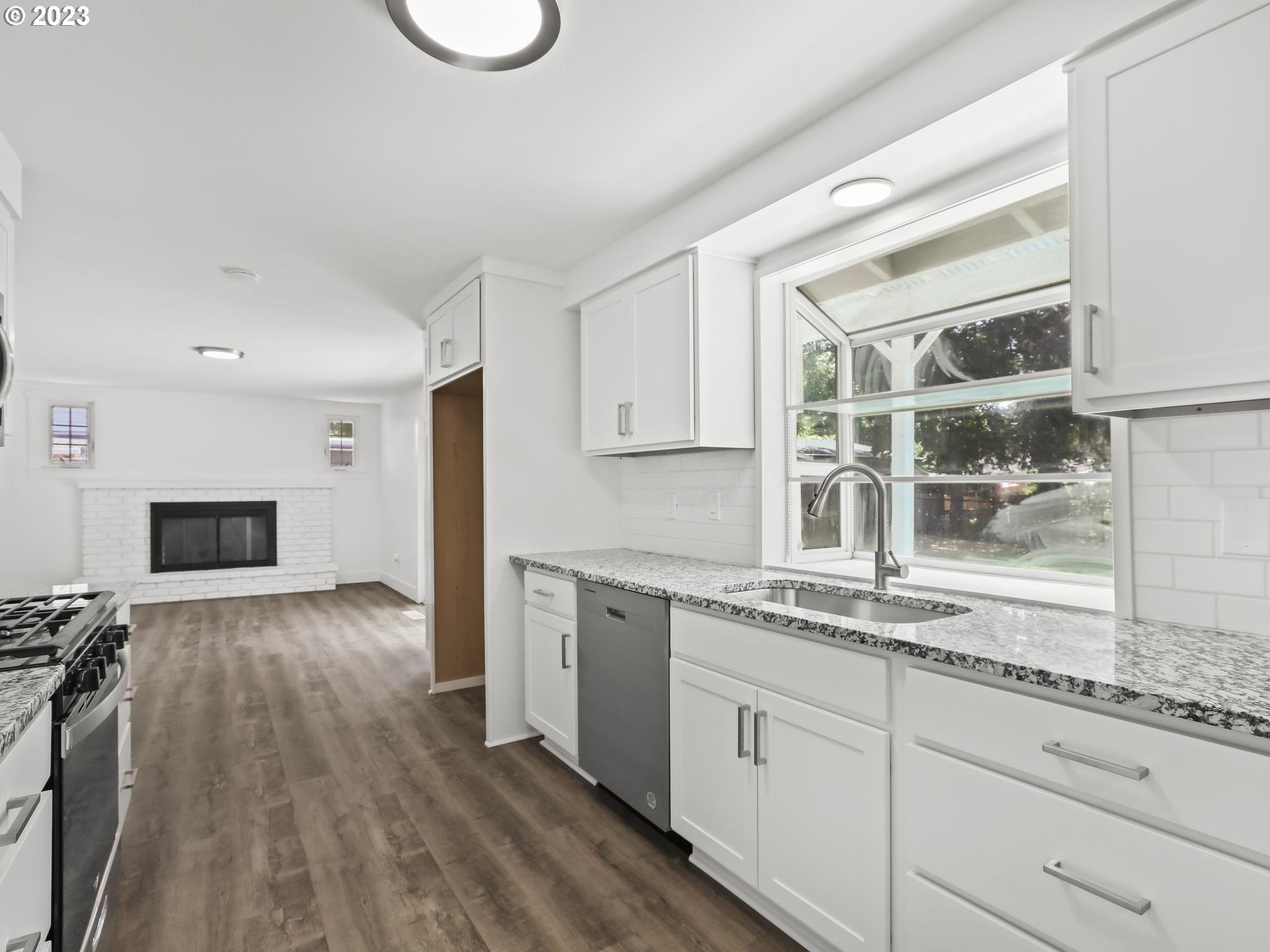 19650 Southwest Celebrity Street Beaverton, OR 97078 - Photo 9 of 47 a kitchen with granite countertop a oven a cabinets and wooden floor