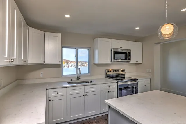 a kitchen with cabinets appliances a sink and a window