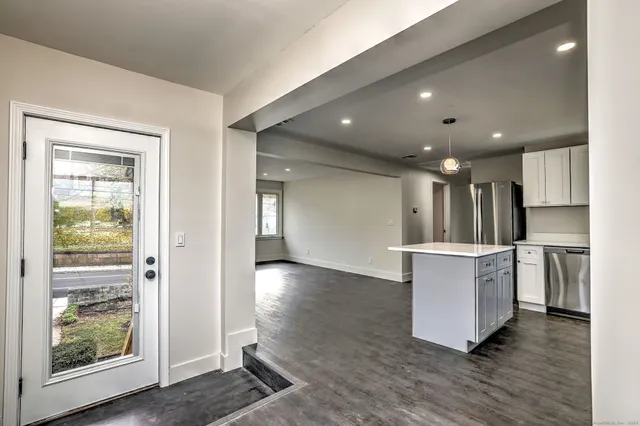 a view of kitchen with stainless steel appliances granite countertop a stove and a refrigerator