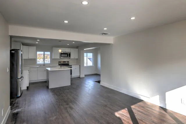 a view of kitchen with sink and refrigerator